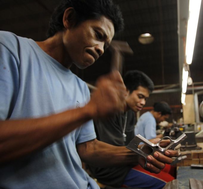 A former illegal gunsmith hammers a newly molded skeletal body of a caliber 45 pistol at Shooters Arms, a gun manufacturing company exporting different kinds of weapons to other countries, in Cebu city in central Philippines July 7, 2012. In the Philippines, they vote with their trigger fingers. Elections mean big business for illegal gunsmiths, who are looking forward to 2013 mid-term polls. With election-related violence commonplace, the Philippines imposes a ban on the carrying of guns for six months, from campaigning to the proclamation of winners. Picture taken July 7, 2012. To match Feature PHILIPPINES-GUNS/ REUTERS/Erik De Castro (PHILIPPINES - Tags: SOCIETY POLITICS BUSINESS CRIME LAW) Published: Čec. 29, 2012, 1:53 dop.