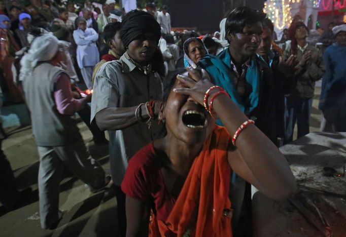 A man pulls the hair of a devotee who is believed to be possessed by evil spirits as she goes into a state of trance at Guru Deoji Maharaj temple during a ghost fair at Malajpur village in Betul district in the central Indian state of Madhya Pradesh January 26, 2013. People from across India come to this fair to be exorcised of �evil spirits�. They are usually brought by relatives and they are most often women. The exorcism involves running around the temple courtyard to make the 'ghost' weak then being beaten by a priest with a broom. Picture taken January 26, 2013. REUTERS/Danish Siddiqui (INDIA - Tags: SOCIETY RELIGION TPX IMAGES OF THE DAY) ATTENTION EDITORS: PICTURE 20 OF 24 FOR PACKAGE 'INDIAN GHOSTBUSTERS' SEARCH 'INDIA GHOST' FOR ALL IMAGES Published: Úno. 5, 2013, 5:10 dop.