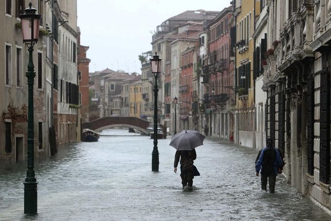 People walk in a flooded street during a period of seasonal high water in Venice November 11, 2012. The water level in the canal city rose to 149 cm (59 inches) above normal, according to local monitoring institute Center Weather Warnings and Tides. REUTERS/Manuel Silvestri (ITALY - Tags: ENVIRONMENT SOCIETY DISASTER) Published: Lis. 11, 2012, 2:35 odp.