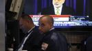 Traders work on the floor of the New York Stock Exchange as a news conference by U.S. Federal Reserve Chairman Ben Bernanke is broadcast on a screen June 20, 2012. REUTERS/Brendan McDermid (UNITED STATES - Tags: BUSINESS POLITICS) Published: Čer. 20, 2012, 8:28 odp.