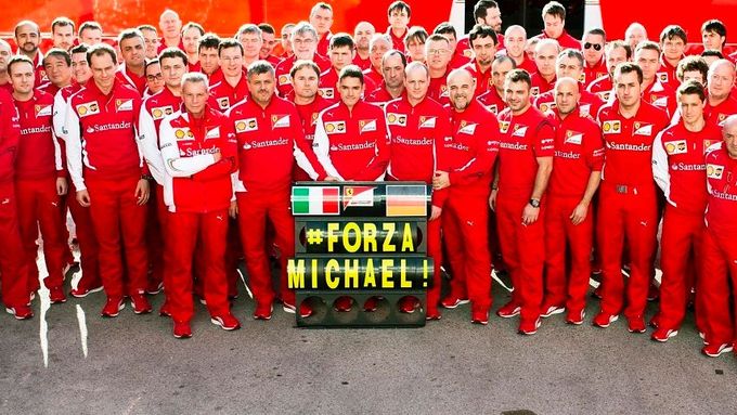 Tým Ferrari s cedulí Forza Michael!