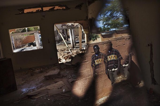 Resident Ousmane Togo is reflected on a piece of broken mirror as he surveys the remains of a hotel hit by French air strikes in Douentza, Mali January 29, 2013. The hotel was used as a base for Islamists and was hit by French air strikes over a week ago. REUTERS/Joe Penney (MALI - Tags: POLITICS CIVIL UNREST CONFLICT TPX IMAGES OF THE DAY) Published: Led. 29, 2013, 1:55 odp.