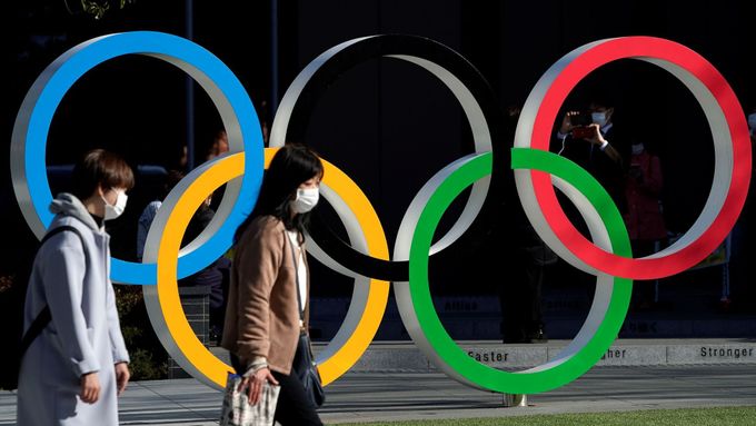 Ženy v rouškách míjí v Tokiu symbol olympijských kruhů