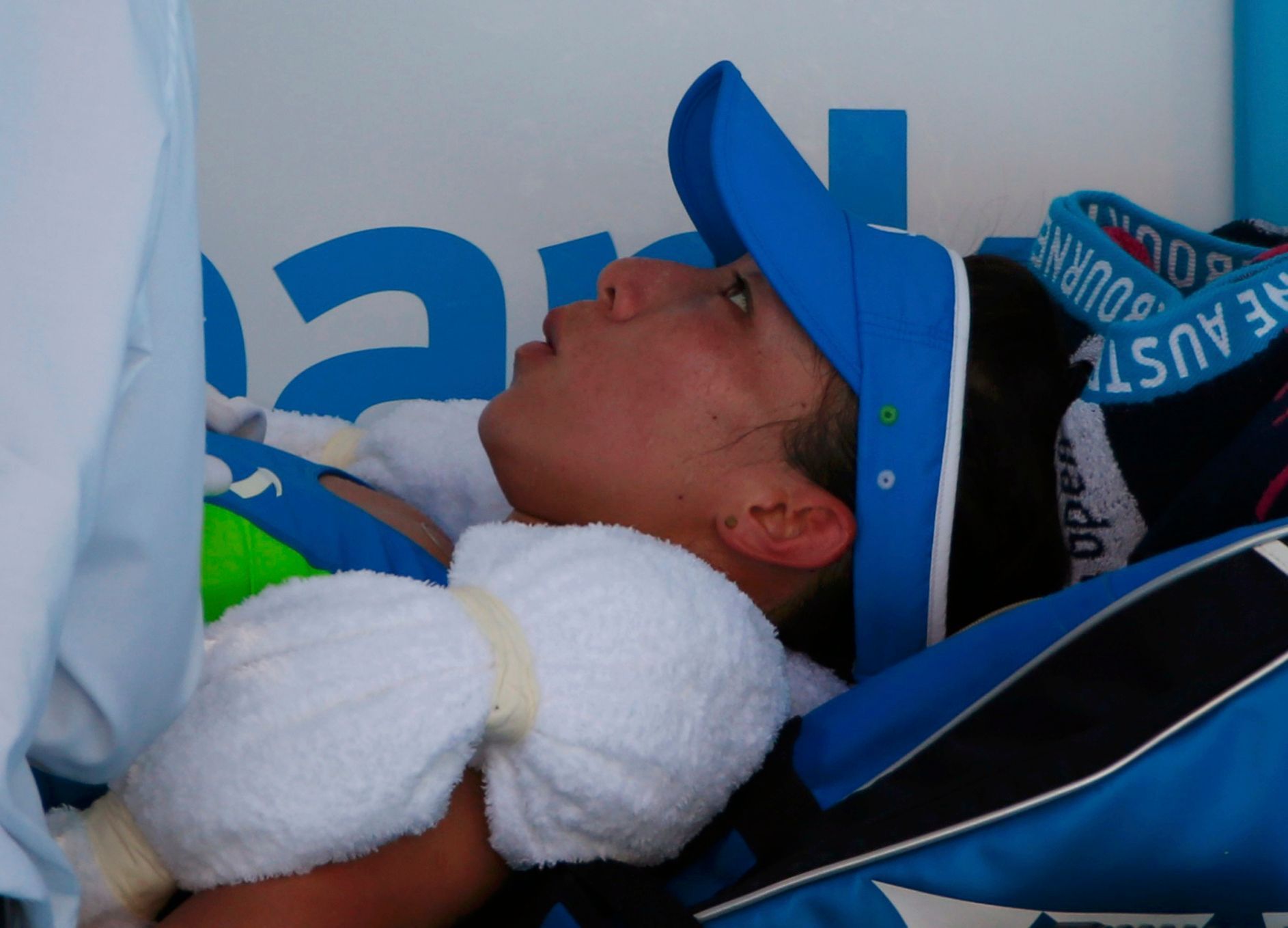 Zheng Jie of China rests on a bench during a medical timeout during her women's singles match against Casey Dellacqua of Australia at the Australian Open 2014 tennis tournament in Melbourne