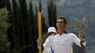 Spyridon Gianniotis, Greece's world champion of swimming, runs with the Olympic flame and an olive branch during the Olympic torch relay at the site of ancient Olympia in Greece May 10, 2012. REUTERS/John Kolesidis (GREECE - Tags: SPORT OLYMPICS) Published: Kvě. 10, 2012, 10:30 dop.