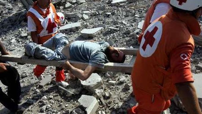 Pracovníci Červeného kříže odnášejí muže, zraněného při dnešním izraelském bombardování Kany na jihu Libanonu.