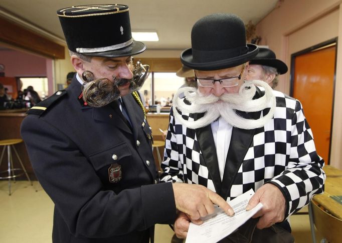 Participants read documents as they take part in the 2012 European Beard and Moustache Championships in Wittersdorf near Mulhouse, Eastern France, September 22, 2012. More than a hundred participants competed in the first European Beard and Moustache Championships organized in France. REUTERS/Vincent Kessler (FRANCE - Tags: SOCIETY) Published: Zář. 22, 2012, 7:33 odp.