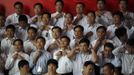 Trainees prepare to pose for a group photo after finishing a training course at the communist party school called China Executive Leadership Academy of Pudong in Shanghai, September 24, 2012. China's Communist Party has dramatically stepped up its training of the country's roughly 40 million party and government officials in the past decade. With public scrutiny of cadre behaviour growing via social media, the party is likely to call for continued, and deepened, cadre education at the upcoming 18th Party Congress. At the vanguard of this education drive, alongside a Central Party School in Beijing, are three "Executive Leadership Academies" which opened in 2005 for middle-ranking and senior officials in Shanghai, Yan'an and Jinggangshan. The curriculum covers Marxism, Leninism and Mao Zedong Thought, but students may also take finance courses, receive in-depth media training or role-play crisis management scenarios on everything from disease outbreaks to train wrecks. REUTERS/Carlos Barria (CHINA - Tags: POLITICS SOCIETY TPX IMAGES OF THE DAY) Published: Zář. 24, 2012, 2:02 odp.