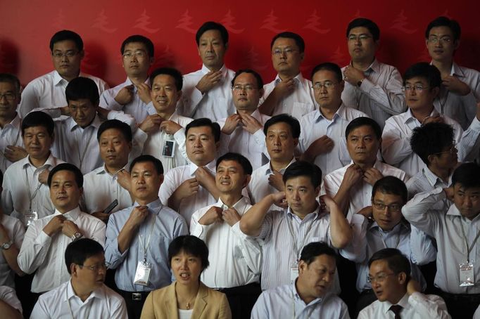 Trainees prepare to pose for a group photo after finishing a training course at the communist party school called China Executive Leadership Academy of Pudong in Shanghai, September 24, 2012. China's Communist Party has dramatically stepped up its training of the country's roughly 40 million party and government officials in the past decade. With public scrutiny of cadre behaviour growing via social media, the party is likely to call for continued, and deepened, cadre education at the upcoming 18th Party Congress. At the vanguard of this education drive, alongside a Central Party School in Beijing, are three "Executive Leadership Academies" which opened in 2005 for middle-ranking and senior officials in Shanghai, Yan'an and Jinggangshan. The curriculum covers Marxism, Leninism and Mao Zedong Thought, but students may also take finance courses, receive in-depth media training or role-play crisis management scenarios on everything from disease outbreaks to train wrecks. REUTERS/Carlos Barria (CHINA - Tags: POLITICS SOCIETY TPX IMAGES OF THE DAY) Published: Zář. 24, 2012, 2:02 odp.