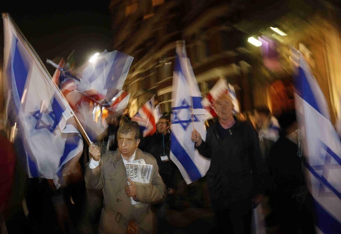 Pro-Israel demonstrators hold Israeli flags during a protest outside Israel's embassy in central London November 15, 2012. Israeli aircraft attacked targets throughout the Gaza Strip on Thursday night, unleashing dozens of strikes in swift succession according to Reuters witnesses. The airstrikes marked an escalation of two days of reciprocal attacks between the Palestinian militant Hamas group ensconced in the coastal enclave and the Israeli military, which killed a top Islamist leader on Wednesday. REUTERS/Stefan Wermuth (BRITAIN - Tags: SOCIETY POLITICS CIVIL UNREST) Published: Lis. 15, 2012, 9:07 odp.