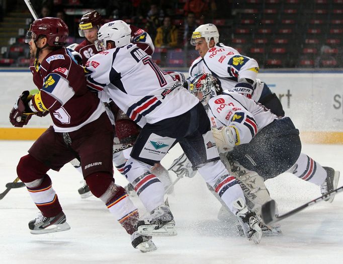 Hokejisté Chomutova Tomáš Bartejs a brankář Milan Řehoř brání Michala Broše a Petra Tenkráta v utkání 16. kola Tipsport extraligy 2012/13 proti Spartě Praha.