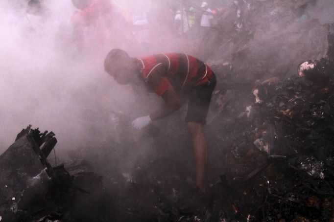 A rescue worker searches the rubble for victims after a plane crashed into a neighbourhood in Ishaga district, an outskirt of Nigeria's commercial capital Lagos June 3, 2012. There were no survivors among the 147 people on board a domestic passenger aircraft that crashed in the Nigerian city of Lagos on Sunday, an official of the National Emergency Management Agency (NEMA), told Reuters. REUTERS/Akintunde Akinleye (NIGERIA - Tags: DISASTER TRANSPORT) Published: Čer. 3, 2012, 9:02 odp.