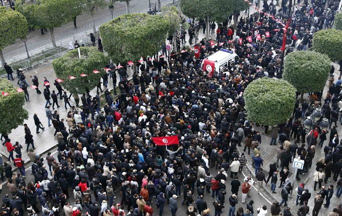 The body of Tunisian opposition Chokri Belaid (top R) arrives amidst tens of thousands of protesters as they demonstrate on Avenue Habib Bourguiba in Tunis February 6, 2013. Tunisia's secular opposition Popular Front said it was pulling out of the constituent assembly charged with writing a constitution after an opposition politician was killed on Wednesday. REUTERS/Anis Mili (TUNISIA - Tags: POLITICS CIVIL UNREST) Published: Úno. 6, 2013, 6:55 odp.