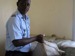 Příslušník senegalské pobřežní policie ukazuje část ze zabavených 2,5 tuny kokainu, který zřejmě směřoval do Guinea-Bissau. Svědčí o tom letenky, které policie zabavila překupníkům