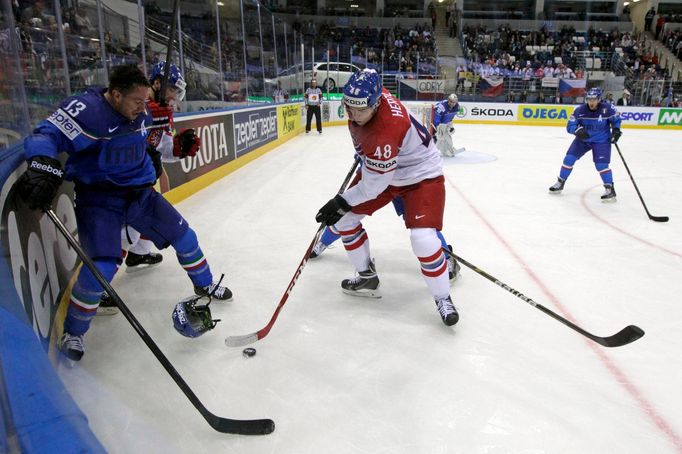 Tomas Hertl of the Czech Republic (C) chases the puck past by Italy's Nathan di Casimiro (L) during the second period of their men's ice hockey World Championship Group A