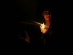 Žena drží svíčku uvnitř památníku genocidy v Jerevanu