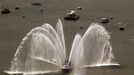 Fire boats spray water in front of the Space Shuttle Enterprise as it floats up the Hudson River June 6, 2012, as it rides past the New York skyline on a barge to be placed at the Intrepid Sea, Air and Space Museum. REUTERS/Lucas Jackson (UNITED STATES - Tags: SCIENCE TECHNOLOGY TRANSPORT) Published: Čer. 6, 2012, 5:09 odp.