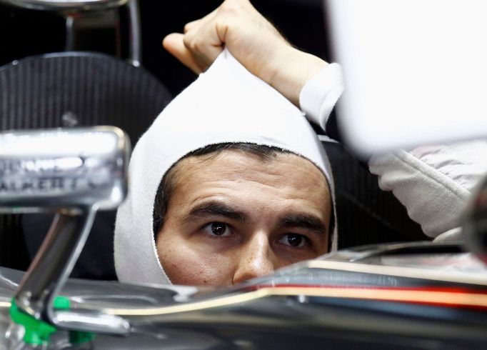 McLaren Formula One driver Sergio Perez of Mexico adjusts his balaclava in his car during the third practice session of the Canadian F1 Grand Prix at the Circuit Gilles V