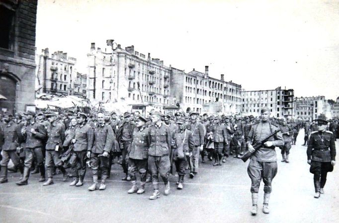 Zajatí němečtí vojáci procházejí pod dohledem Rudé armády ulicemi rozbombardovaného Kyjeva.