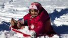 A child is pulled by her parents during a ride down a hill on toboggan after a winter storm in Jersey City, New Jersey, February 9, 2013. A blizzard packing hurricane-force winds pummelled the northeastern United States on Saturday, killing at least one person, leaving about 600,000 customers without power and disrupting thousands of flights. REUTERS/Eduardo Munoz (UNITED STATES - Tags: ENVIRONMENT DISASTER) Published: Úno. 10, 2013, 12:35 dop.