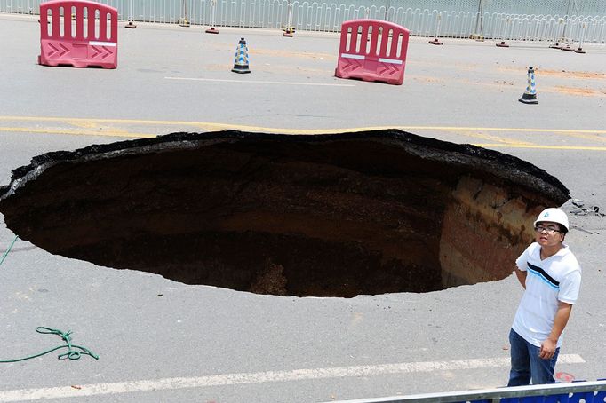 Giant sinkhole opens on road in Changsha, Hunan Province, China - 05 Jul 2012 2012-07-05 00:00:00 Mandatory Credit: Photo by Quirky China News / Rex Features (1793113a) The sinkhole Giant sinkhole opens on road in Changsha, Hunan Province, China - 05 Jul 2012 A huge sinkhole has suddenly appeared on a main road in Changsha, capital of southern China's Hunan Province. The enormous hole opened up at around 1am and swallowed up a car - killing one and injuring a further three people. The street has now been blocked off and the local infrastructure office plans to fill it back in. It is not known what caused the sinkhole to form.