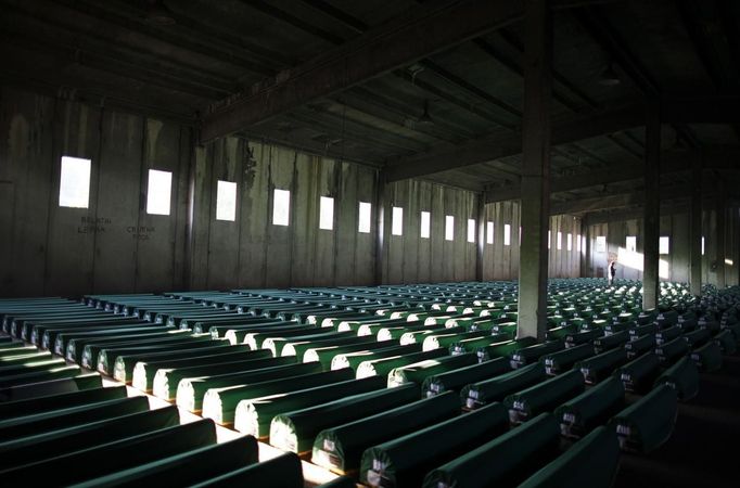 A Bosnian Muslim man prays near coffins prepared for a mass burial at the Memorial Center in Potocari, near Srebrenica July 9, 2012. The bodies of 520 recently identified victims of the Srebrenica massacre will be buried on July 11, the anniversary of the massacre when Bosnian Serb forces commanded by Ratko Mladic slaughtered 8,000 Muslim men and boys and buried them in mass graves, in Europe's worst massacre since World War Two. REUTERS/Dado Ruvic (BOSNIA - Tags: ANNIVERSARY CONFLICT POLITICS) Published: Čec. 9, 2012, 5:48 odp.