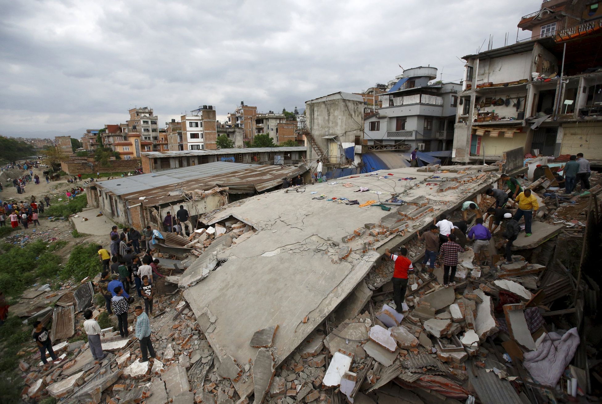 People gather near a collapsed house after major earthquake in Kathmandu