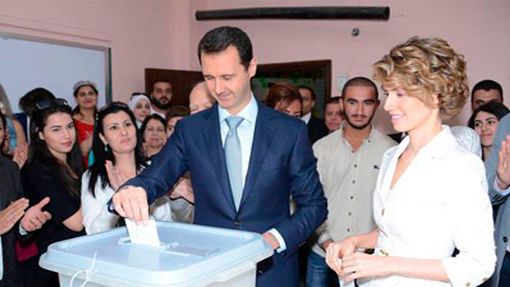 Syrský prezident Bašár Asad odevzdává hlas v prezidentských volbách. Pozoruje ho manželka Asma (vpravo).