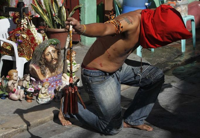 REFILE - ADDING ADDITIONAL CAPTION INFORMATION A hooded penitent with a bloodied back prays in front of an image of Jesus Christ during Maundy Thursday Lenten rites in Mandaluyong city, metro Manila March 28, 2013. Maundy Thursday or Holy Thursday is the day Christians commemorate the Last Supper of Jesus Christ. Holy Week is celebrated in many Christian traditions during the week before Easter. REUTERS/Romeo Ranoco (PHILIPPINES - Tags: POLITICS RELIGION SOCIETY) Published: Bře. 28, 2013, 5:57 dop.