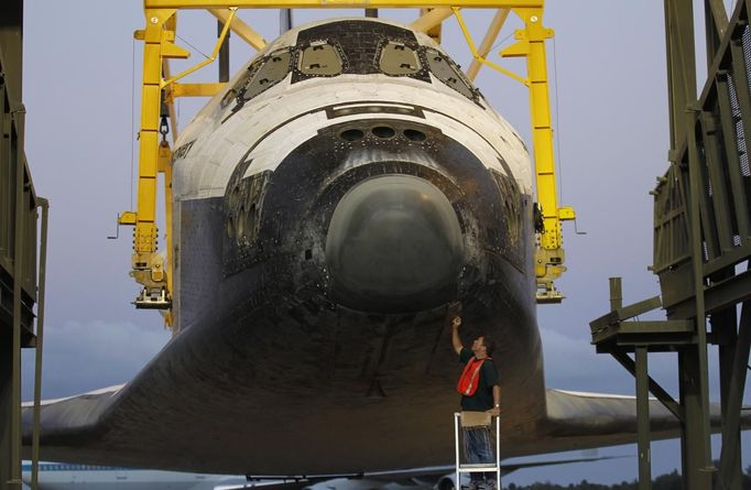 A space center technician works on the nose section of the space shuttle Discovery before it was elevated in the Mate Demate facility at Kennedy Space Center in Cape Canaveral