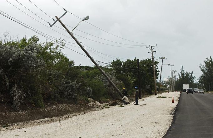 Workers repair a utility pole damaged by Hurricane Sandy in Kingston, October 25, 2012. Strengthening rapidly after tearing into Jamaica and crossing the warm Caribbean Sea, Sandy hit southeastern Cuba early on Thursday with 105-mph winds that cut power and blew over trees, with at least three fatalities in Jamaica and Haiti. REUTERS/Gilbert Bellamy (JAMAICA - Tags: ENVIRONMENT DISASTER) Published: Říj. 25, 2012, 5:58 odp.