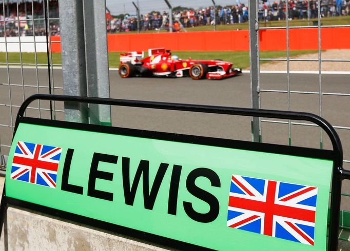 Ferrari Formula One driver Fernando Alonso of Spain drives past the pit board of Mercedes driver Lewis Hamilton of Britain during the final practice session for the Briti