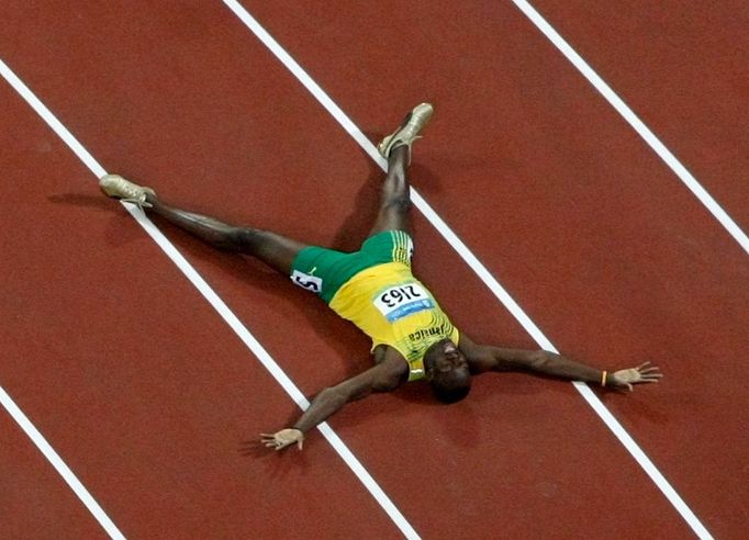 SPRINT - Usain Bolt v málo očekávané pozici na zádech. Jamajský rychlík neměl mezi sprintery konkurenci. Takto slavil vítězství v závodě na 200 metrů.