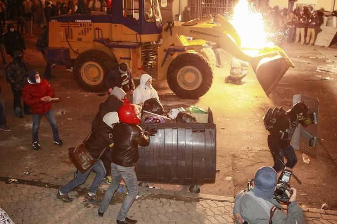 Demonstranti se snaží prorazit policejní linie.