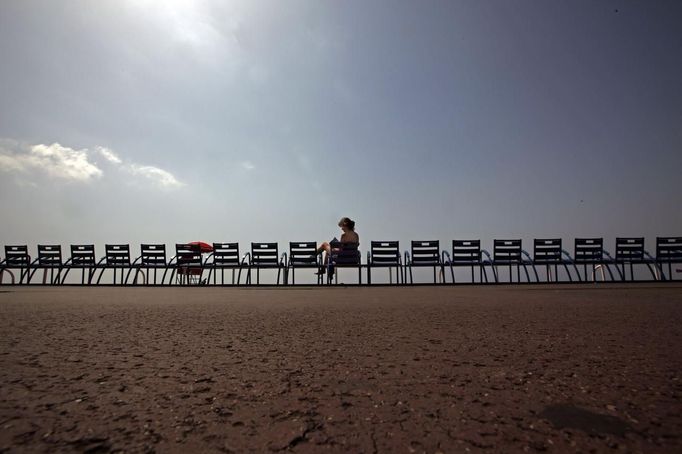 A woman enjoys the sun on the Promenade des Anglais as temperatures are close to 30 degrees Celsius (86 Fahrenheit) in Nice June 29, 2012. REUTERS/Eric Gaillard (FRANCE - Tags: TRAVEL ENVIRONMENT) Published: Čer. 29, 2012, 1:13 odp.