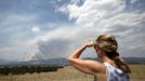 A woman watches as the city of Colorado Springs, Colorado is in the path of the Waldo Canyon wildfire burning in the mountains west of the city June 24, 2012. Firefighters in Western U.S. states struggled to contain out-of-control wind-stoked wildfires across the U.S. west as summer temperatures mounted, and a fresh blaze consumed more homes in Colorado. REUTERS/Rick Wilking (UNITED STATES - Tags: DISASTER ENVIRONMENT) Published: Čer. 24, 2012, 6:06 odp.