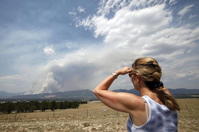 A woman watches as the city of Colorado Springs, Colorado is in the path of the Waldo Canyon wildfire burning in the mountains west of the city June 24, 2012. Firefighters in Western U.S. states struggled to contain out-of-control wind-stoked wildfires across the U.S. west as summer temperatures mounted, and a fresh blaze consumed more homes in Colorado. REUTERS/Rick Wilking (UNITED STATES - Tags: DISASTER ENVIRONMENT) Published: Čer. 24, 2012, 6:06 odp.