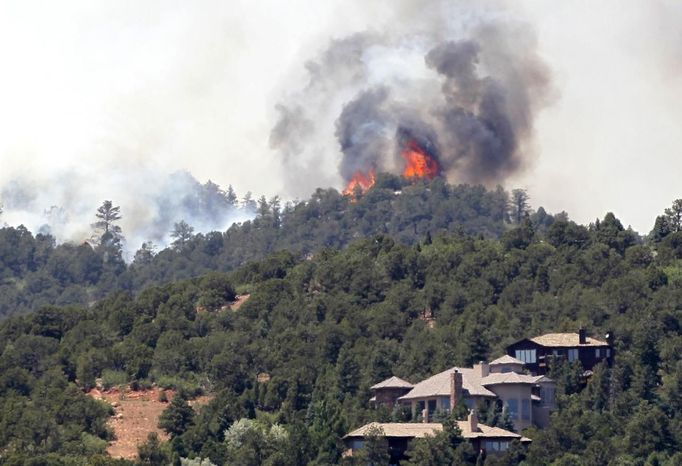 Fire continues to burn near homes in the Waldo Canyon fire west of Colorado Springs, Colorado June 25, 2012. A fast-growing wildfire in Colorado forced 11,000 people from their homes at least briefly and threatened popular summer camping grounds beneath Pikes Peak, whose vistas helped inspire the patriotic tune "America the Beautiful." REUTERS/Rick Wilking (UNITED STATES - Tags: DISASTER ENVIRONMENT) Published: Čer. 25, 2012, 8:28 odp.