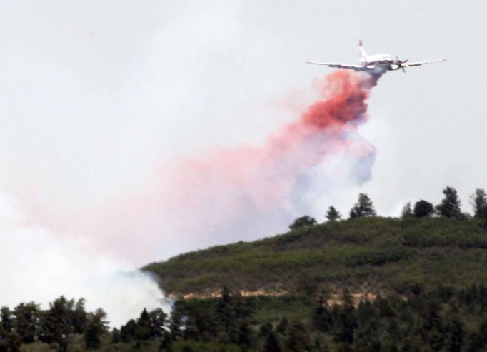 An air tanker dumps flame-retardant on the Waldo Canyon fire, west of Colorado Springs June 24, 2012. A fast-growing wildfire has forced thousands of residents from homes in Colorado Springs, Colorado, and nearby communities as firefighters struggled on Sunday to contain out-of-control and wind-stoked blazes in several western U.S. states. REUTERS/Rick Wilking (UNITED STATES - Tags: DISASTER ENVIRONMENT TRANSPORT) Published: Čer. 24, 2012, 8:25 odp.