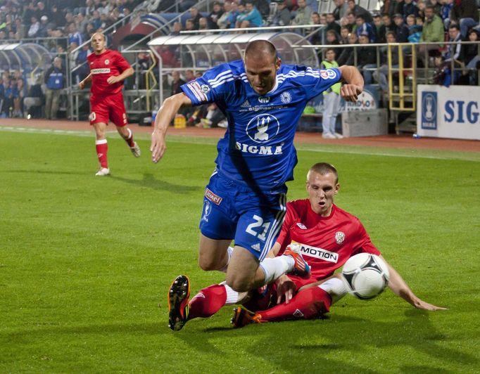 Fotbalista Sigmy Olomouc Michal Vepřek padá přes nohy Martina Husára v utkání 9. kola Gambrinus ligy 2012/13 se Zbrojovkou Brno.