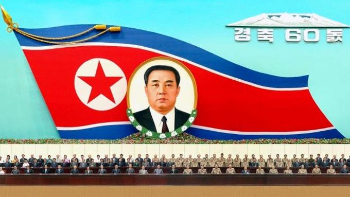 Zasedání Ústředního výboru Korejské strany práce. Na zdi fotografie Kim Ir-sena.
