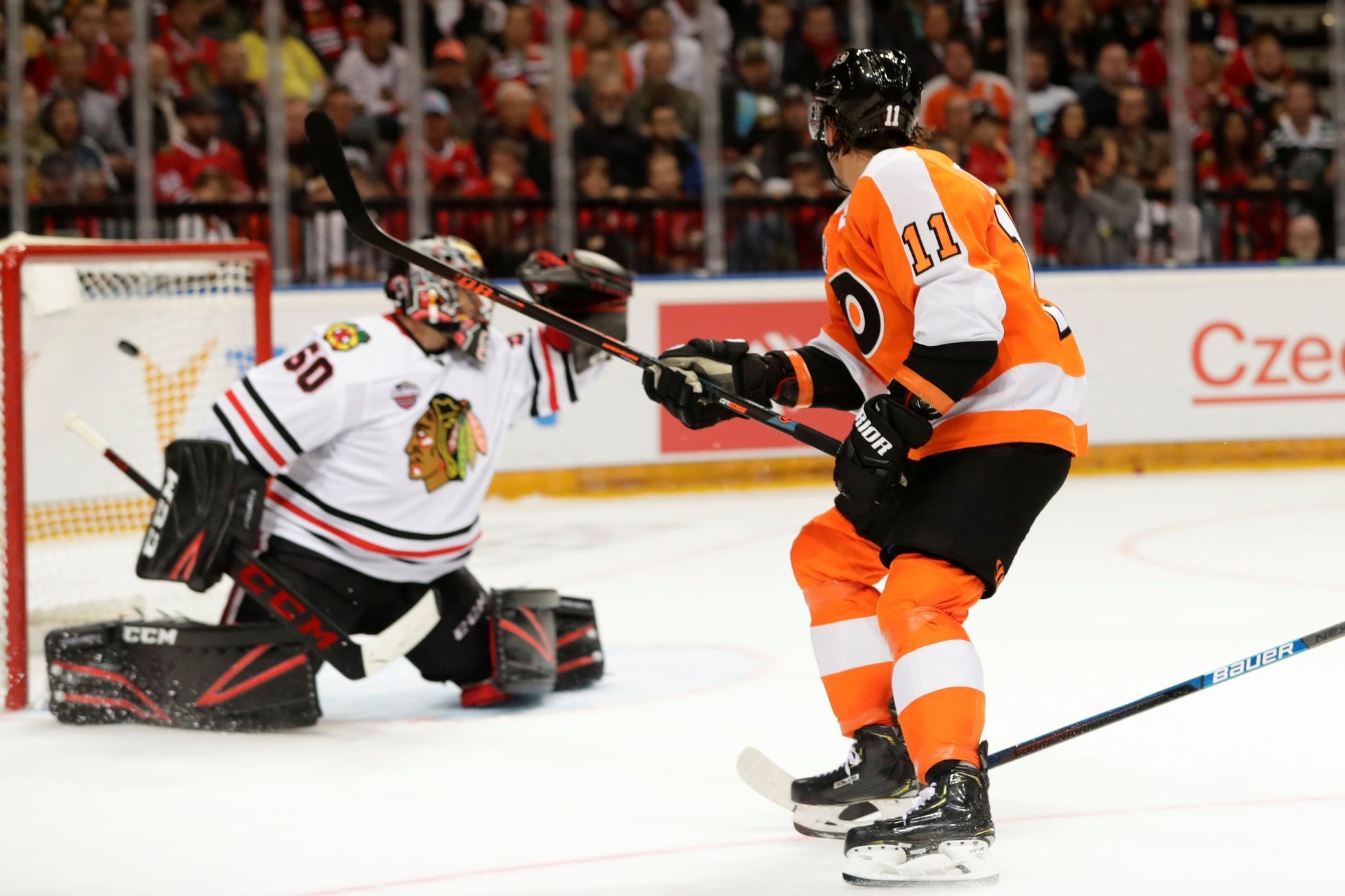 NHL v Praze, Philadelphia - Chicago: Travis Konecny dává brankáři Coreymu Crawfordovi gól na 3:1