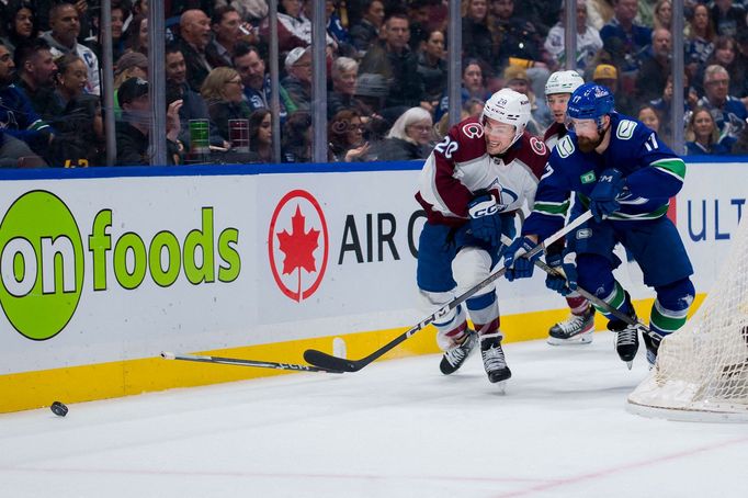 Mar 13, 2024; Vancouver, British Columbia, CAN; Colorado Avalanche forward Ross Colton (20) battles with Vancouver Canucks defenseman Filip Hronek (17) in the second peri