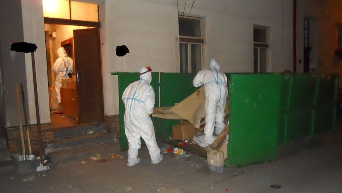 Kriminalistům na místě stěžují práci odpadky nahromaděné v bytě. Celý dům byl zahlcen odpadem.