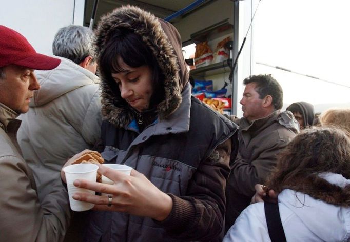 Lidé "nafasovali" tekutiny a jídlo od humanitárních pracovníků. Odnášejí si je do "soukromí" stanů civilní ochrany.