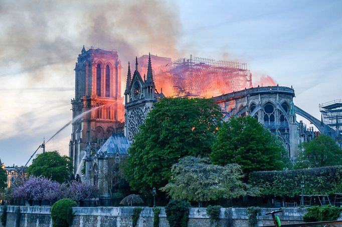 Požár katedrály Notre-Dame v Paříži, 15. dubna 2019, zachycuje plameny a kouř stoupající z ikonické stavby během devastujícího incidentu.