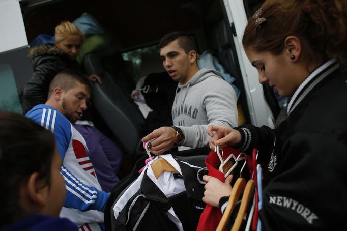 Members of the Gabarri-Valdes family distribute their belongings to different cars after a bulldozer demolished their home at the Spanish gypsy settlement of Puerta de Hierro, in the outskirts of Madrid November 20, 2012. Fifty-four families have been living in Puerta de Hierro, on the banks of the Manzanares river for over 50 years. Since the summer of 2010, the community has been subject to evictions on the grounds that the dwellings are illegal. Families, whose homes have been demolished, move in with relatives whose houses still remain while the debris keeps piling up around them as more demolitions take place. REUTERS/Susana Vera (SPAIN - Tags: CIVIL UNREST BUSINESS CONSTRUCTION) Published: Lis. 20, 2012, 4:56 odp.