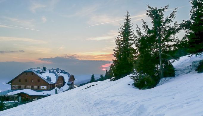 Horská chata Dvoračky  v Krkonoších při západu Slunce během zimního období. Fotografie z roku 2019