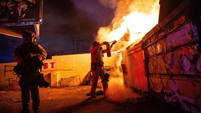 A law enforcement officer works to put out a fire during a protest in Compton, Calif., Saturday, June 7, 2025, after federal immigration authorities conducted operations.