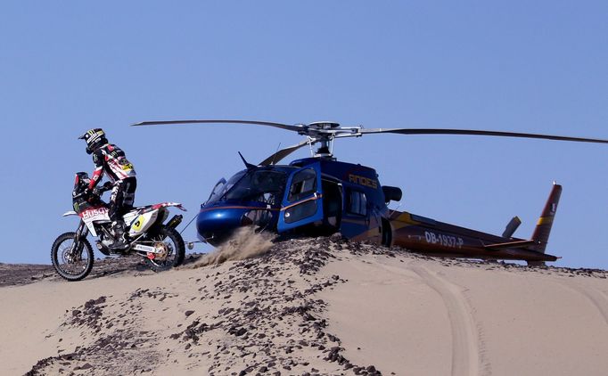 Španěl Joan Bort Barreda projíždí kolem jedné z řady helikoptér, které bdí nad účastníky Rallye Dakar.